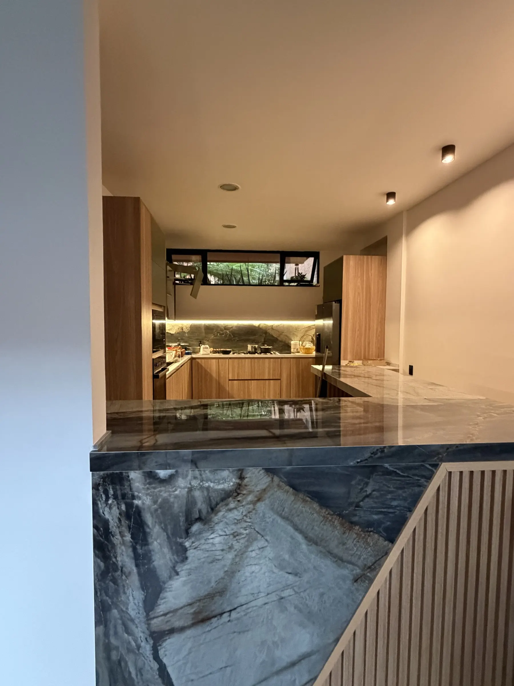 Cocina Casa 8 · La cocina en U, con la barra y el acento de color. · IO's Architecture